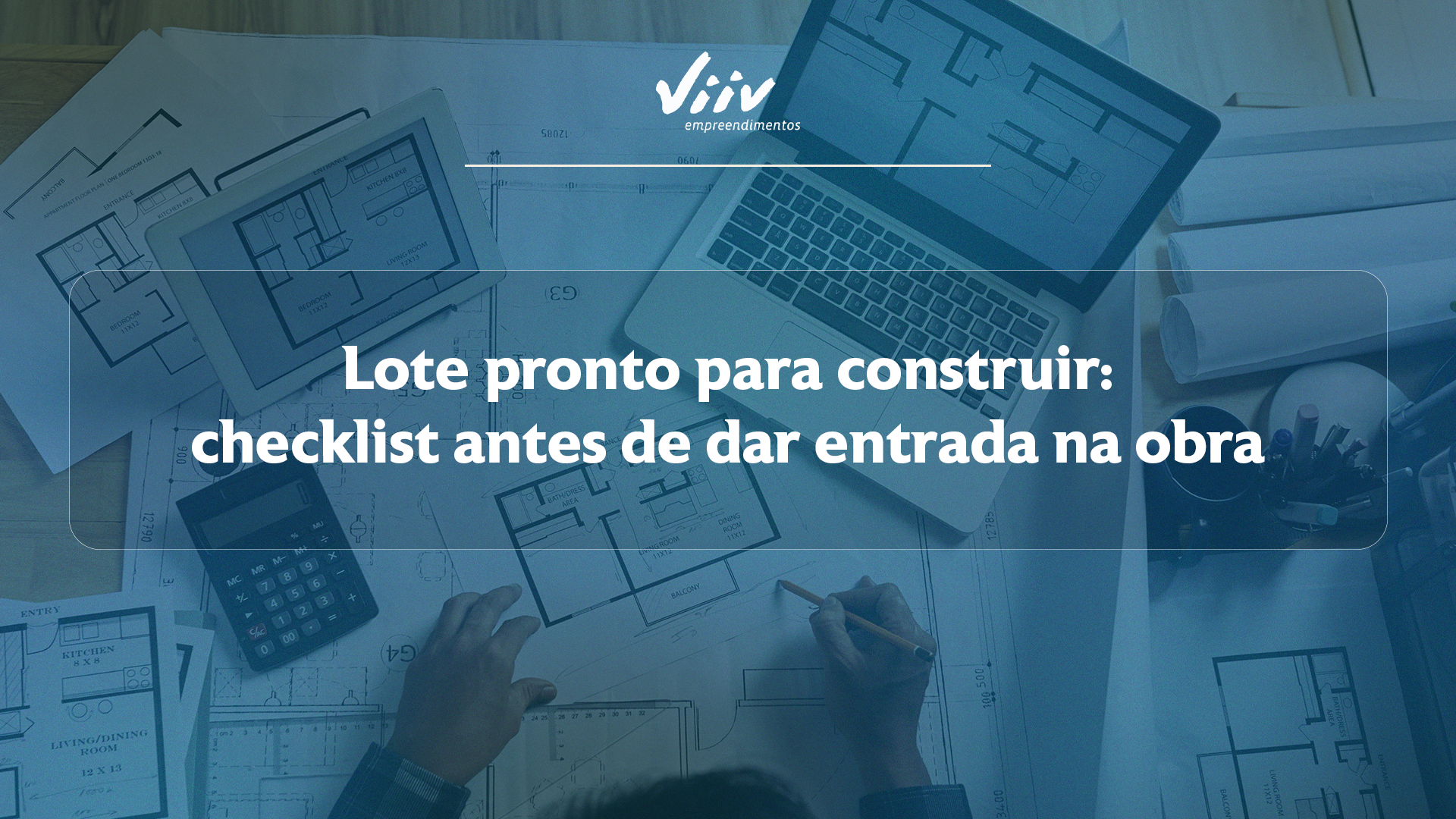 Vista superior de uma mesa de trabalho com plantas arquitetônicas, tablet, computador portátil e calculadora, com a frase "Lote pronto para construir: checklist antes de dar entrada na obra" e o logótipo da Viiv Empreendimentos